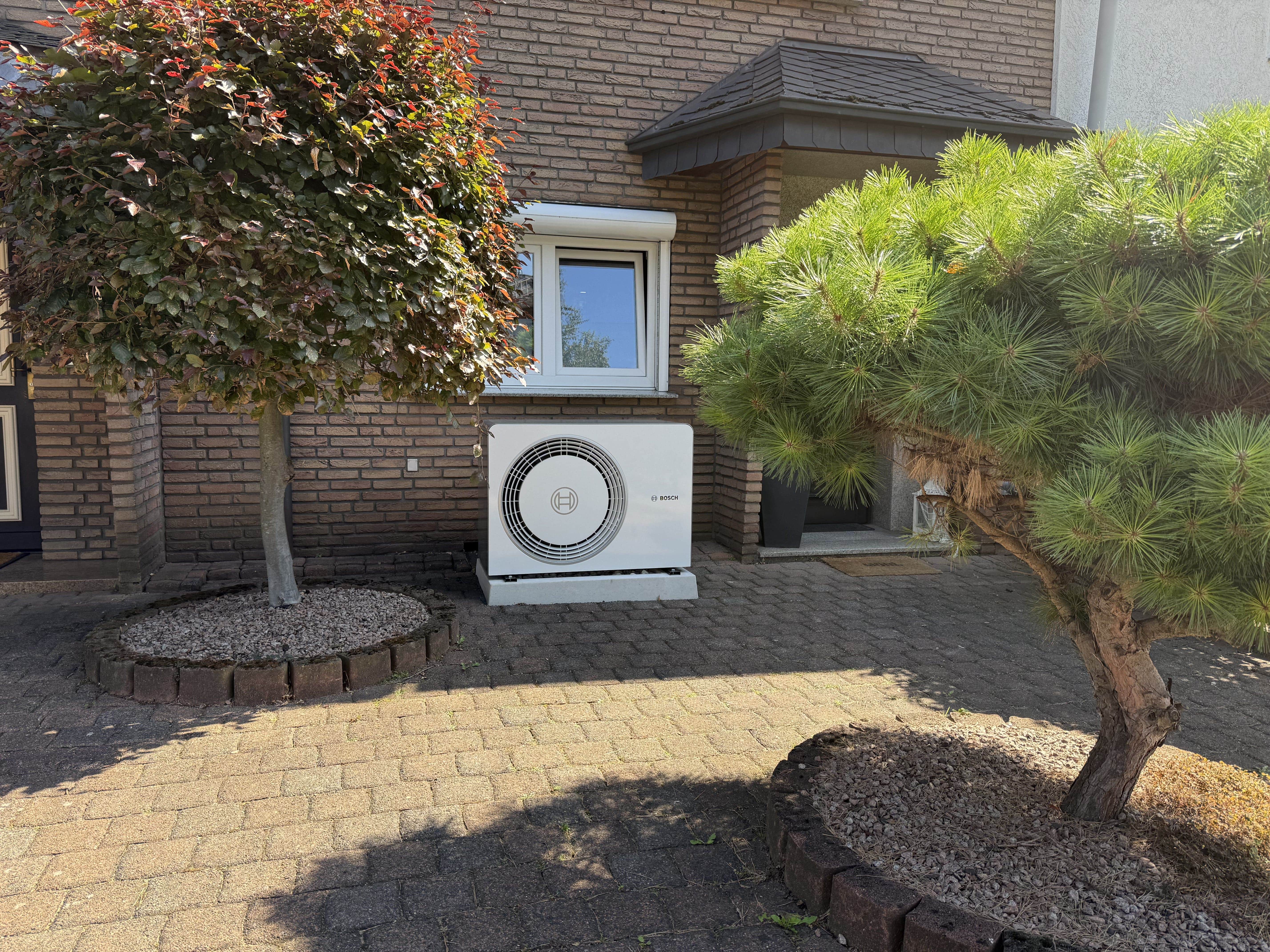 Bosch-Wärmepumpe im Vorgarten eines Einfamilienhauses